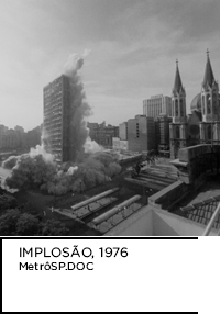 Fotografia preto e branco. Prédio explodindo e desmoronando. Abaixo, “IMPLOSÃO, 1976 MetrôSP.DOC”.