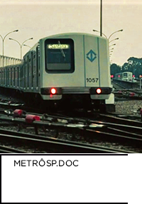 Recorte de imagem do documentário O Metrô de São Paulo, 1990, mostra o trem do metrô localizado no pátio Jabaquara com destino Santana. Abaixo, “O METRÔ DE SÃO PAULO METRÔSP.DOC”.
