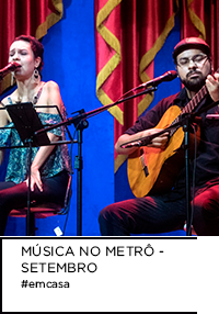 Fotografia de mulher cantando e homem tocando violão.  Abaixo, “MÚSICA NO METRÔ - SETEMBRO #emcasa”.